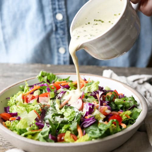 vegan ranch dressing pouring over salad