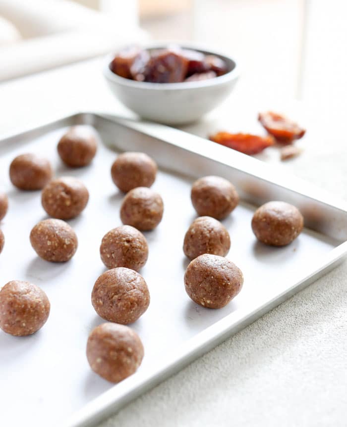 no bake energy bites on sheet pan with dates in background