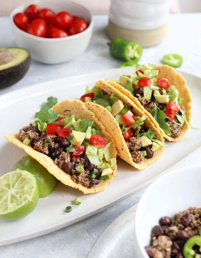 three vegan tacos on a plate with toppings