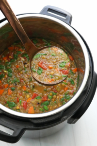 ladle of lentil soup over Instant pot.