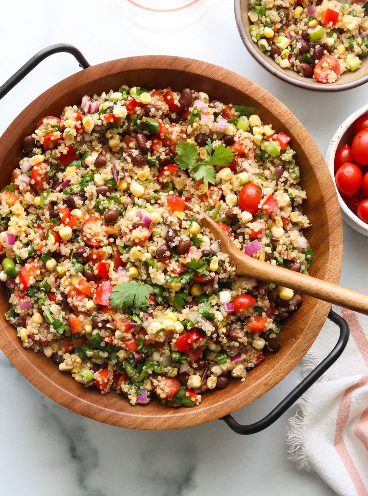 quinoa salad served in a wooden bowl with cilantro on top.