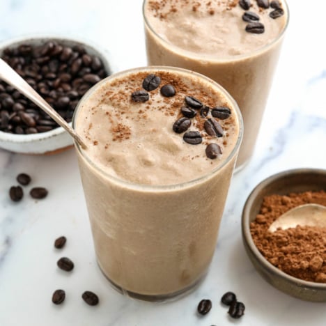 coffee smoothie in 2 glasses topped with coffee beans.