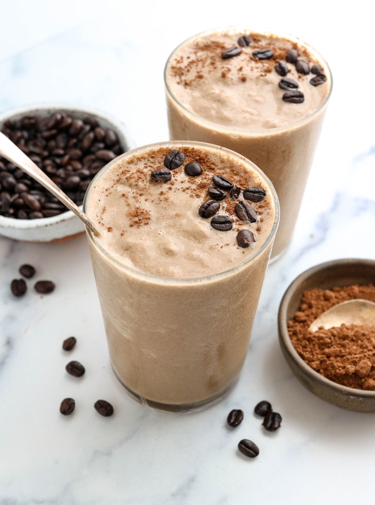 coffee smoothie in 2 glasses topped with coffee beans.