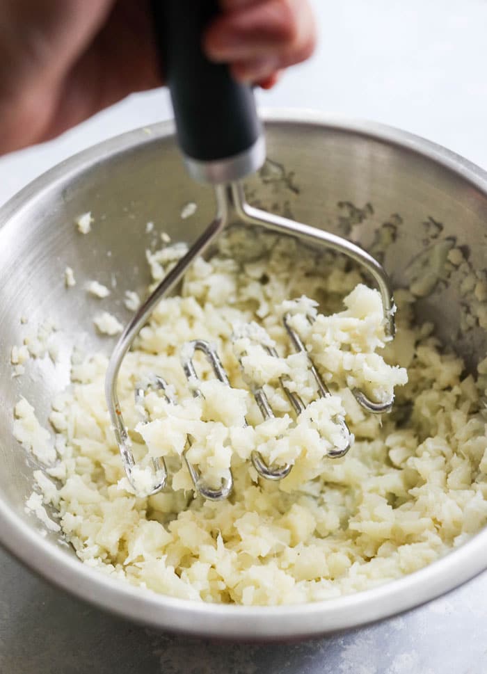 cauliflower rice with potato masher