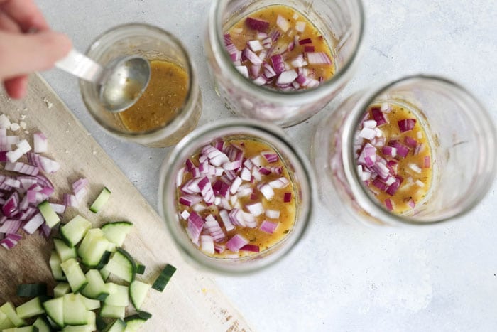 red onions in mason jars with dressing