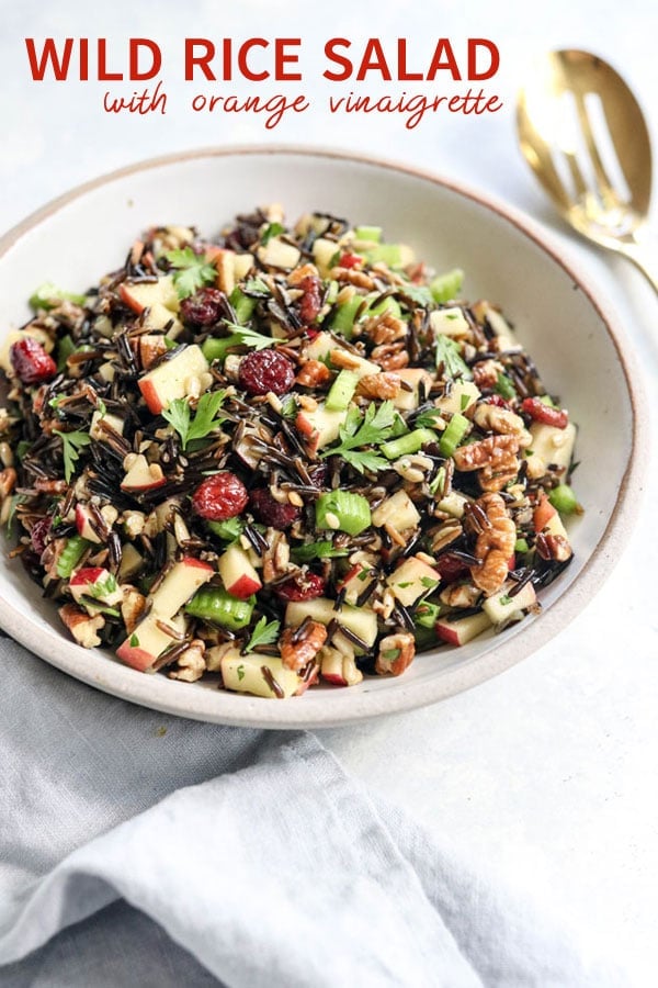 This cold wild rice salad is tossed in an orange vinaigrette, with crisp celery and apples, crunchy pecans, and sweet cranberries. It's a perfect salad for Thanksgiving, and can be made ahead of time for a fast and easy holiday meal loaded with Fall flavors. #healthyrecipe #salad #thanksgiving #holidayrecipe #dairyfree