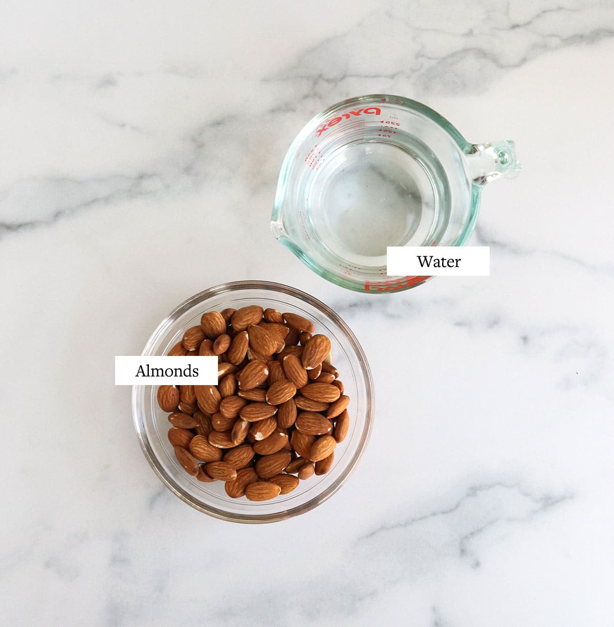 almond milk ingredients labeled on marble surface.