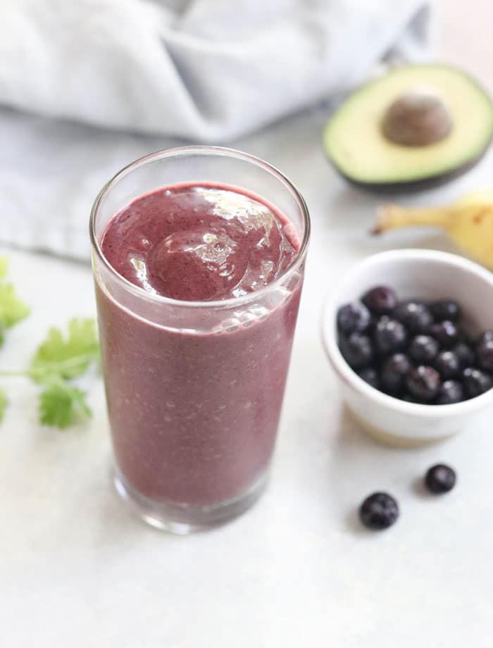 blueberry detox smoothie with bowl of frozen blueberries