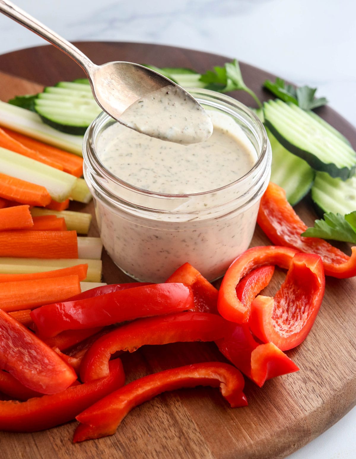 ranch dressing on a spoon surrounded by veggies