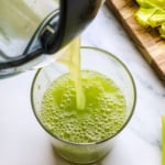 celery juice poured into glass from juicer.