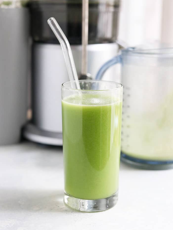 celery juice in glass with straw
