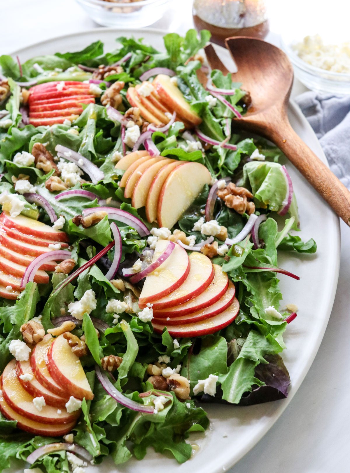 apple walnut salad served on a large platter with dressing on the side.