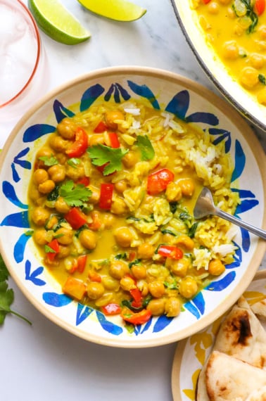 coconut curry served in a colorful bowl with veggies and rice.