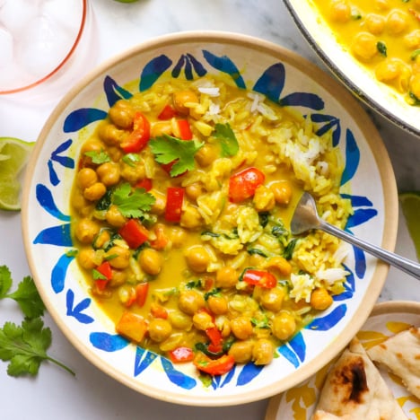 coconut curry served in a colorful bowl with veggies and rice.