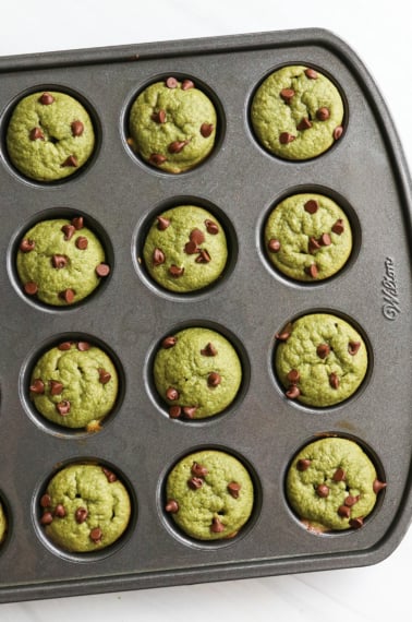 spinach muffins with mini chocolate chips on top in pan.