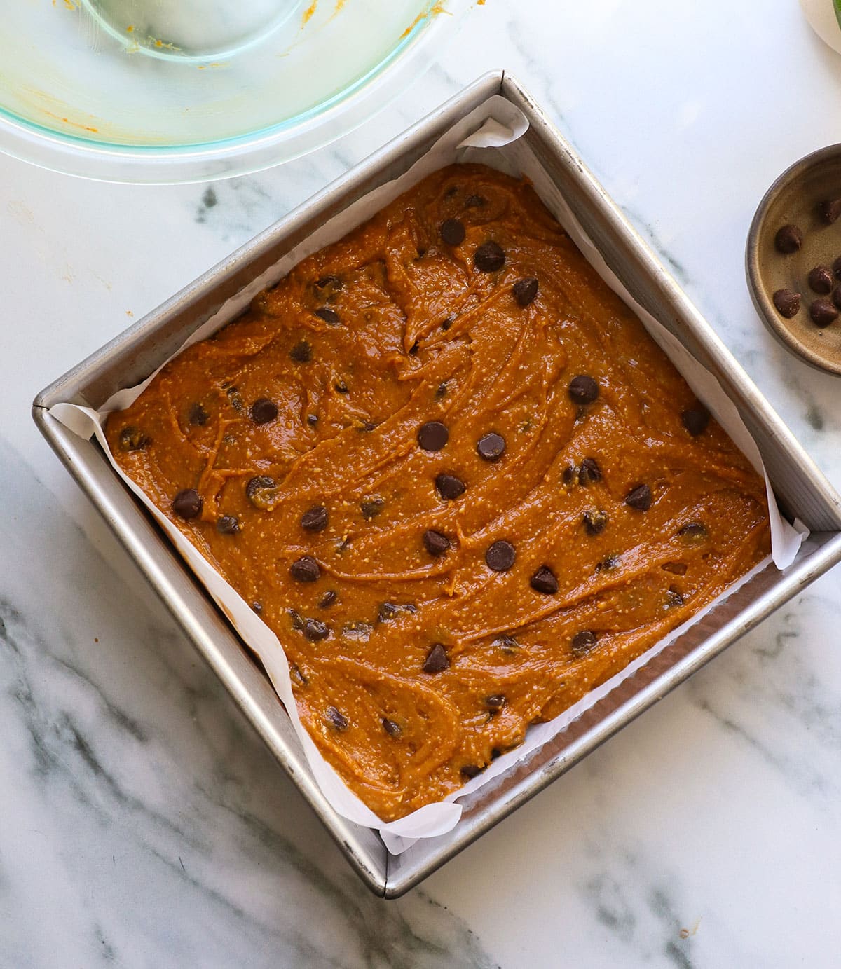 peanut butter mixture spread into the pan with chocolate chips on top.