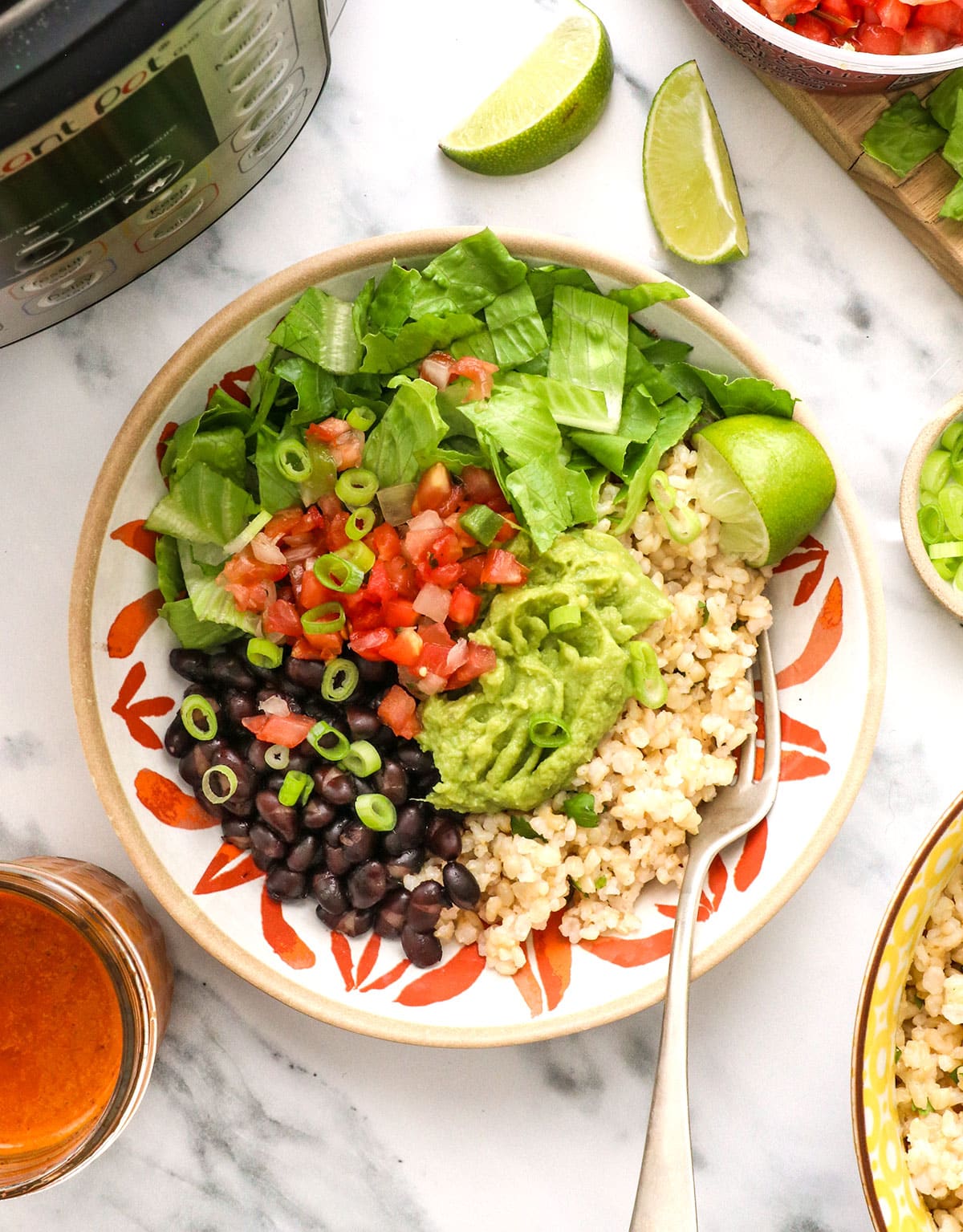 chipotle bowls overhead topped with pico de gallo and guacamole.