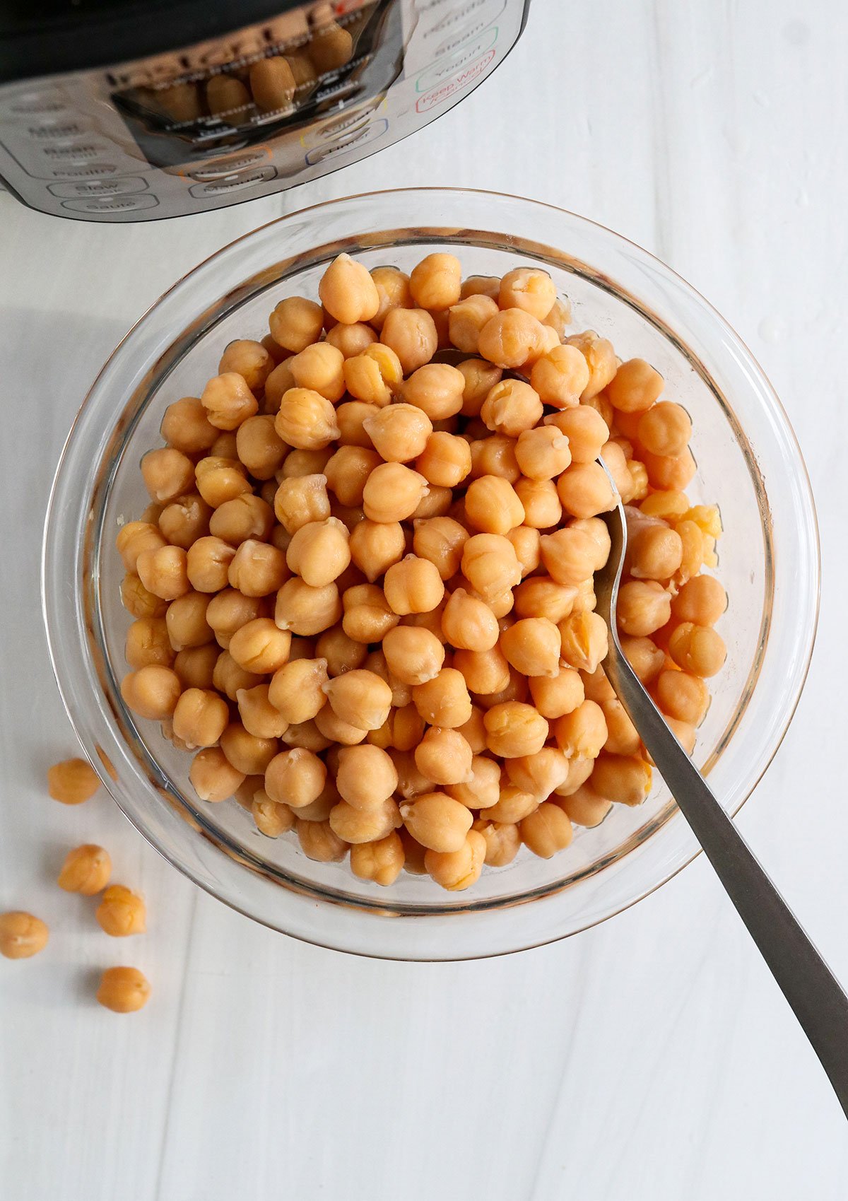 instant pot chickpeas in a glass bowl with spoon.