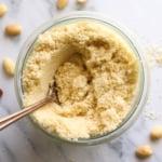 homemade almond flour in a glass jar with a spoon.