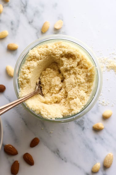 almond flour in a jar near whole almonds on the counter.