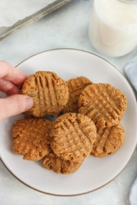 picking up a peanut butter cookies off a plate