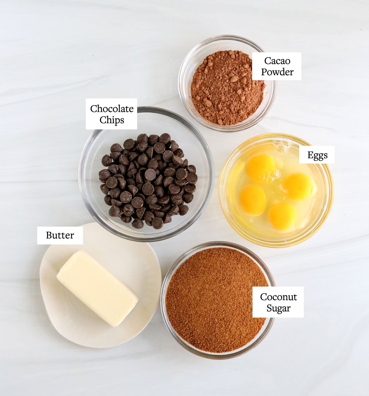 flourless chocolate cake ingredients labeled on white surface.