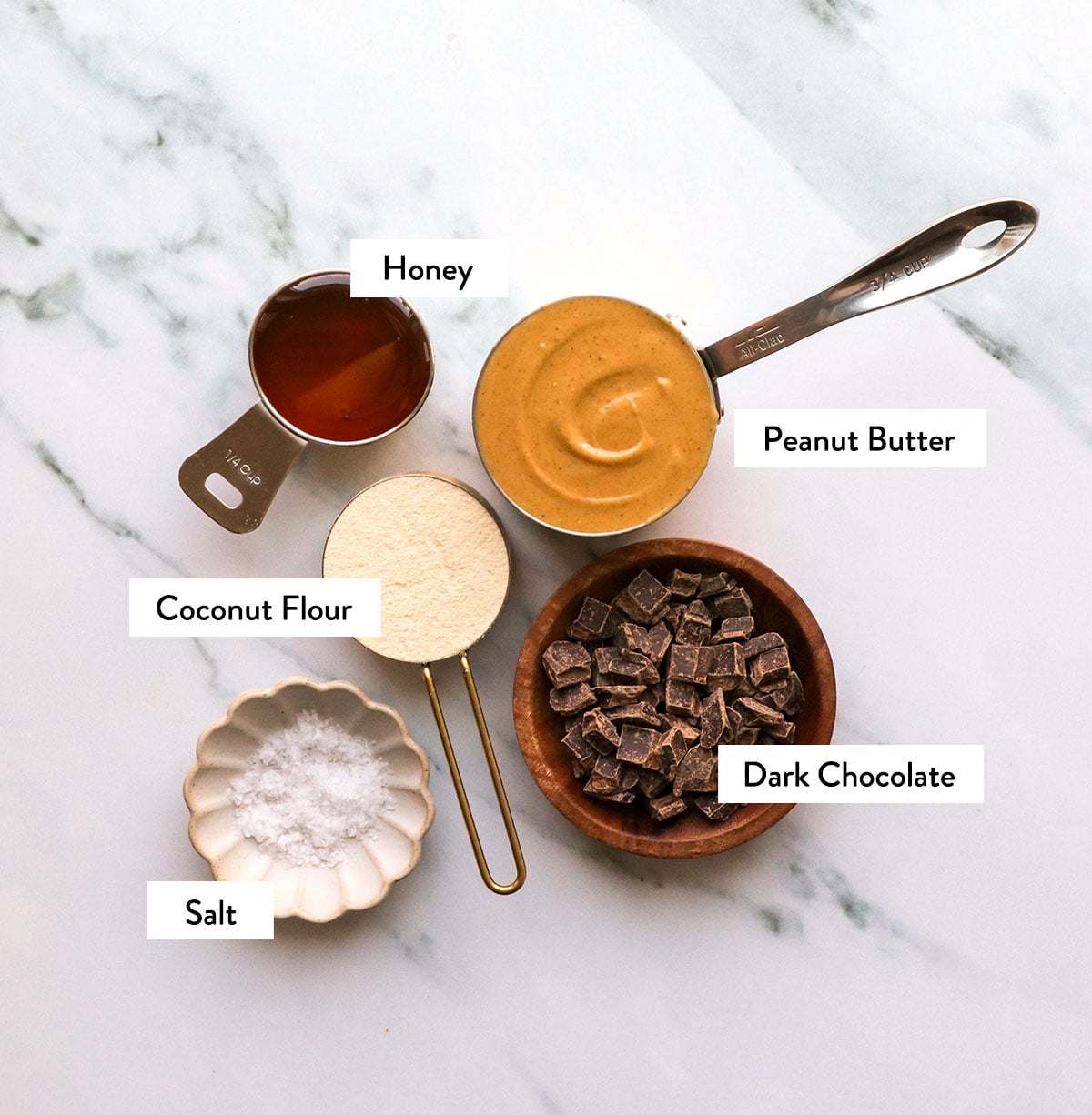 peanut butter, coconut flour, chocolate chips, and honey labeled in measuring cups.