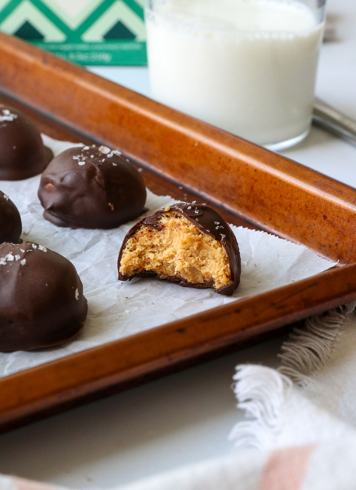 peanut butter ball with bite removed on a pan.