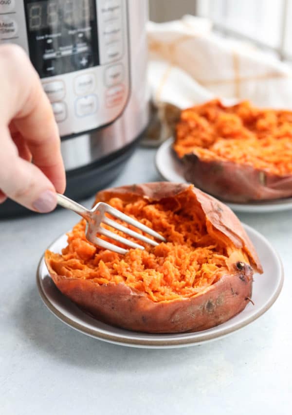 sweet potato being mashed with a fork