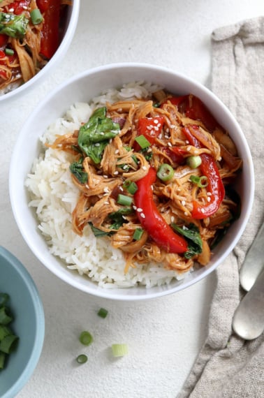 korean chicken bowls served with rice and green onions.