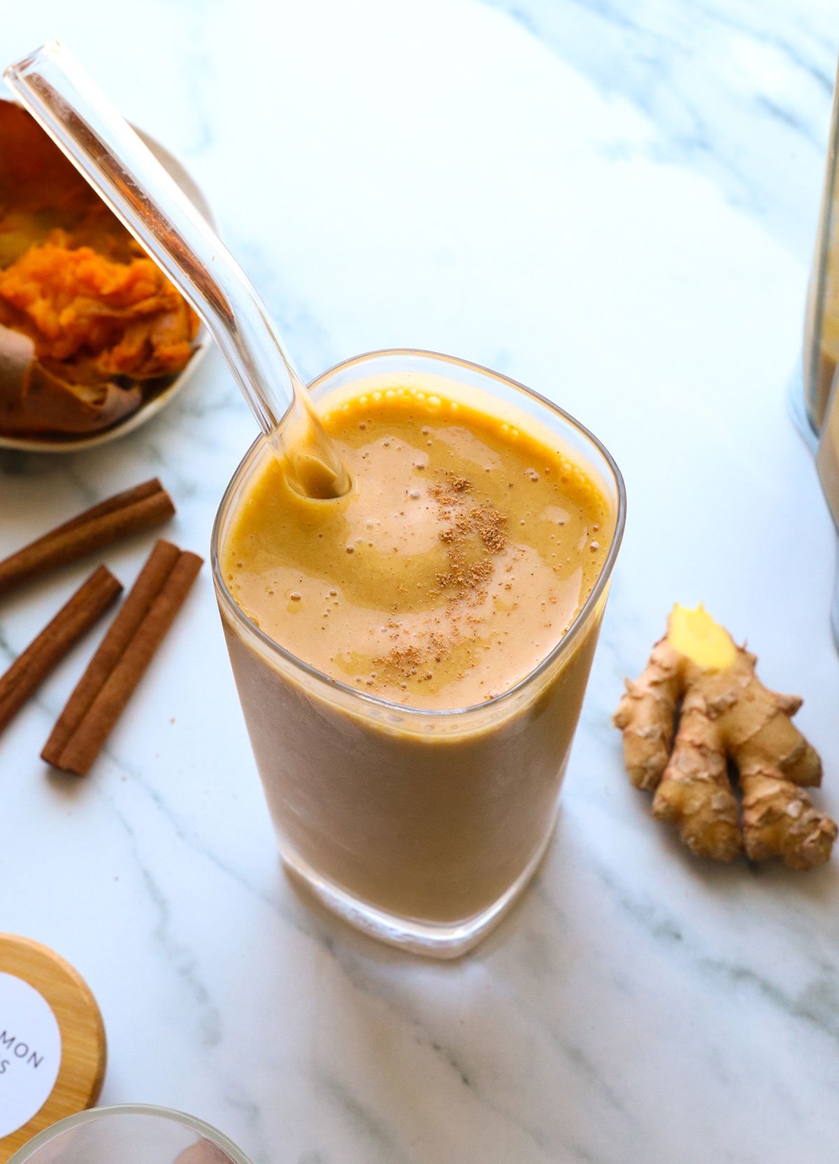 sweet potato smoothie near ginger and cinnamon sticks in a glass. 
