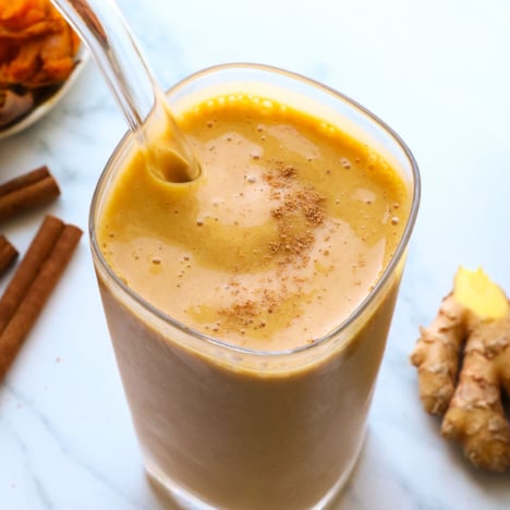 sweet potato smoothie close up with a glass straw.