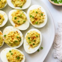 avocado deviled eggs served on a white plate.