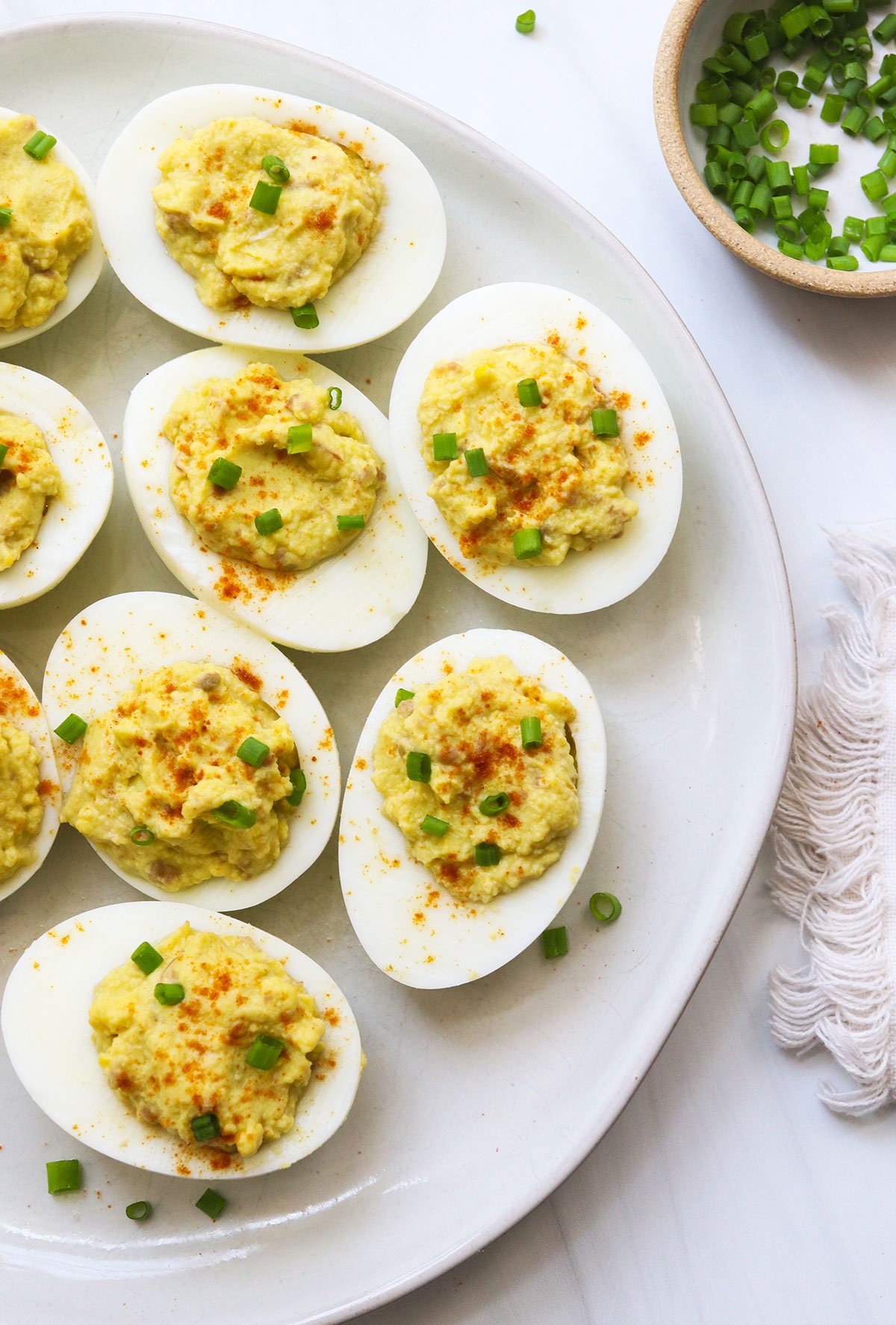 avocado deviled eggs served on a white plate.