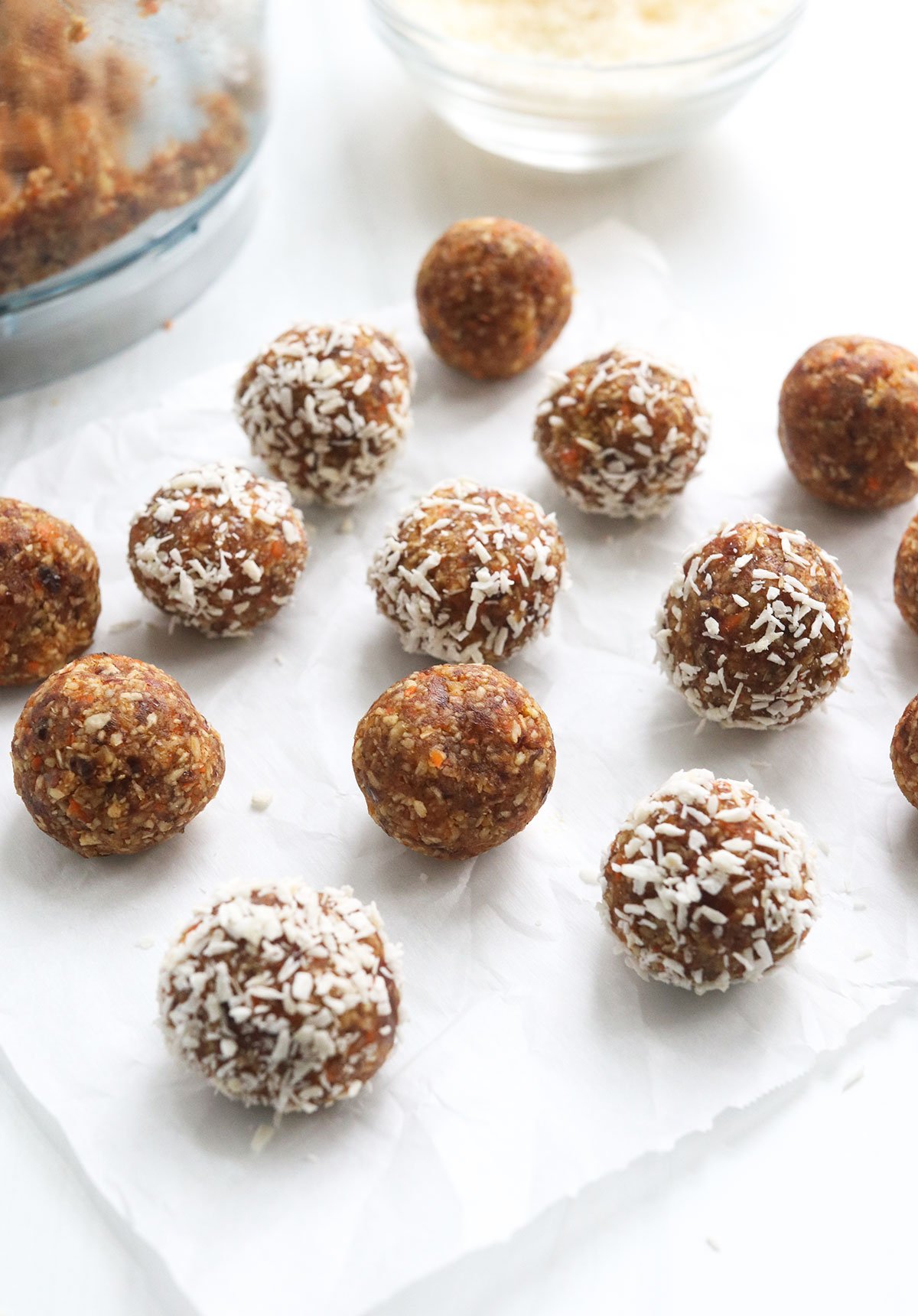 carrot cake balls arranged on parchment paper.