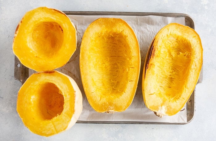 cooked squash on pan cut side up