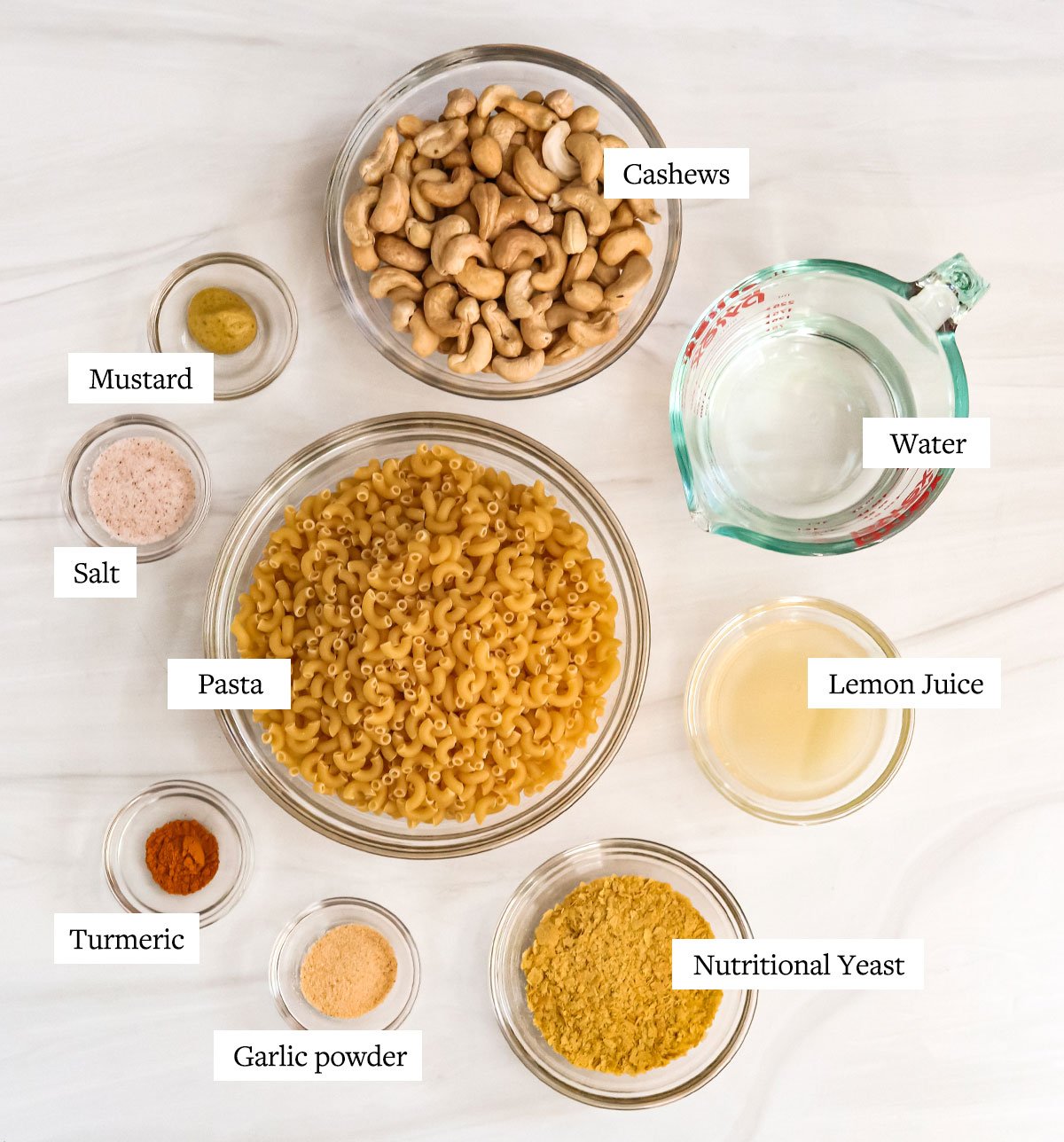vegan mac and cheese ingredients labeled in glass bowls.