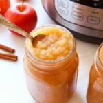 Instant Pot applesauce in two mason jars with a spoon.