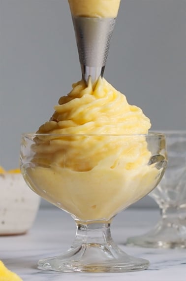 pineapple whip piped from a frosting bag into a dish.