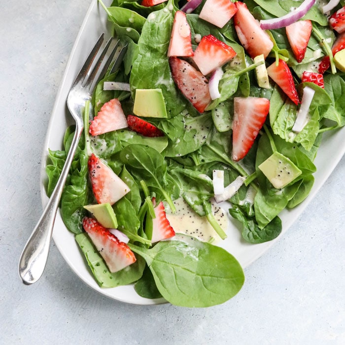 spinach salad leaves with dressing on top