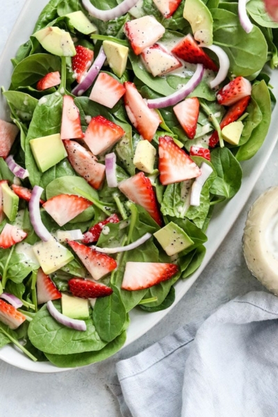 strawberry spinach salad overhead on a white plate