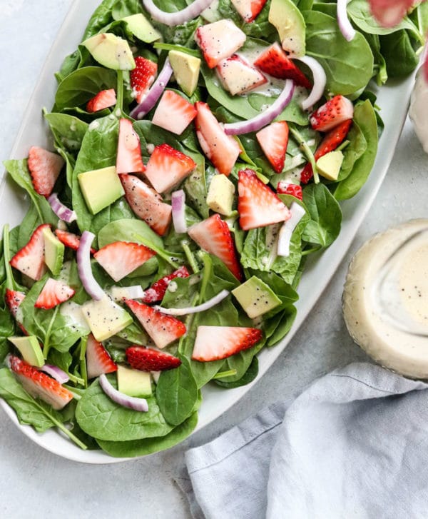 strawberry spinach salad overhead on a white plate
