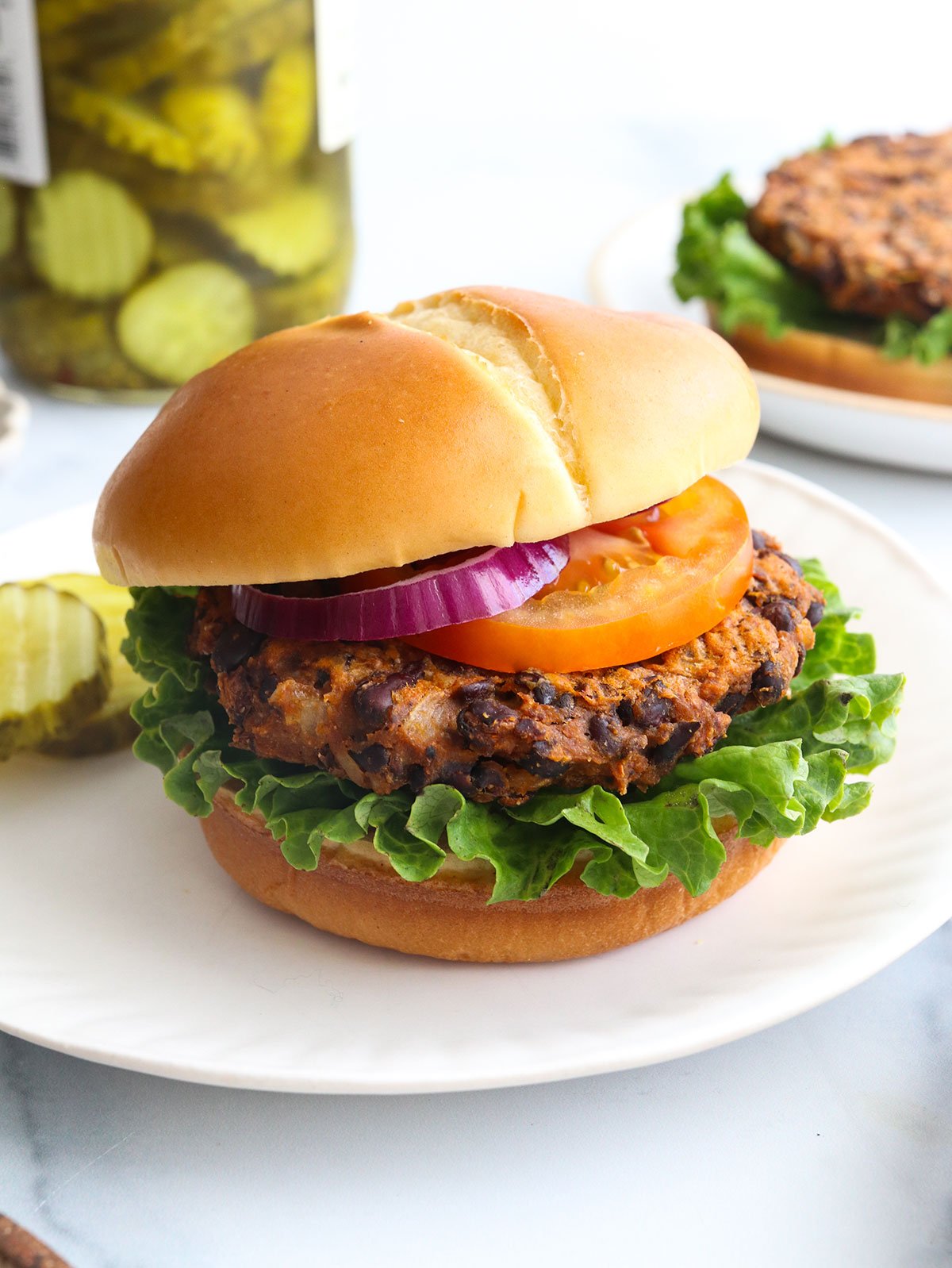 sweet potato black bean burger served on a bun with lettuce and tomato.