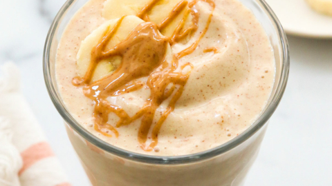 peanut butter banana smoothie topped with peanut butter drizzle.