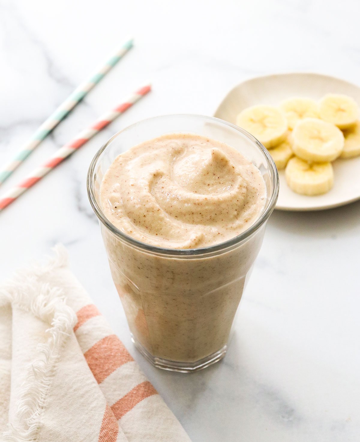 peanut butter banana smoothie in glass that looks like a milkshake.