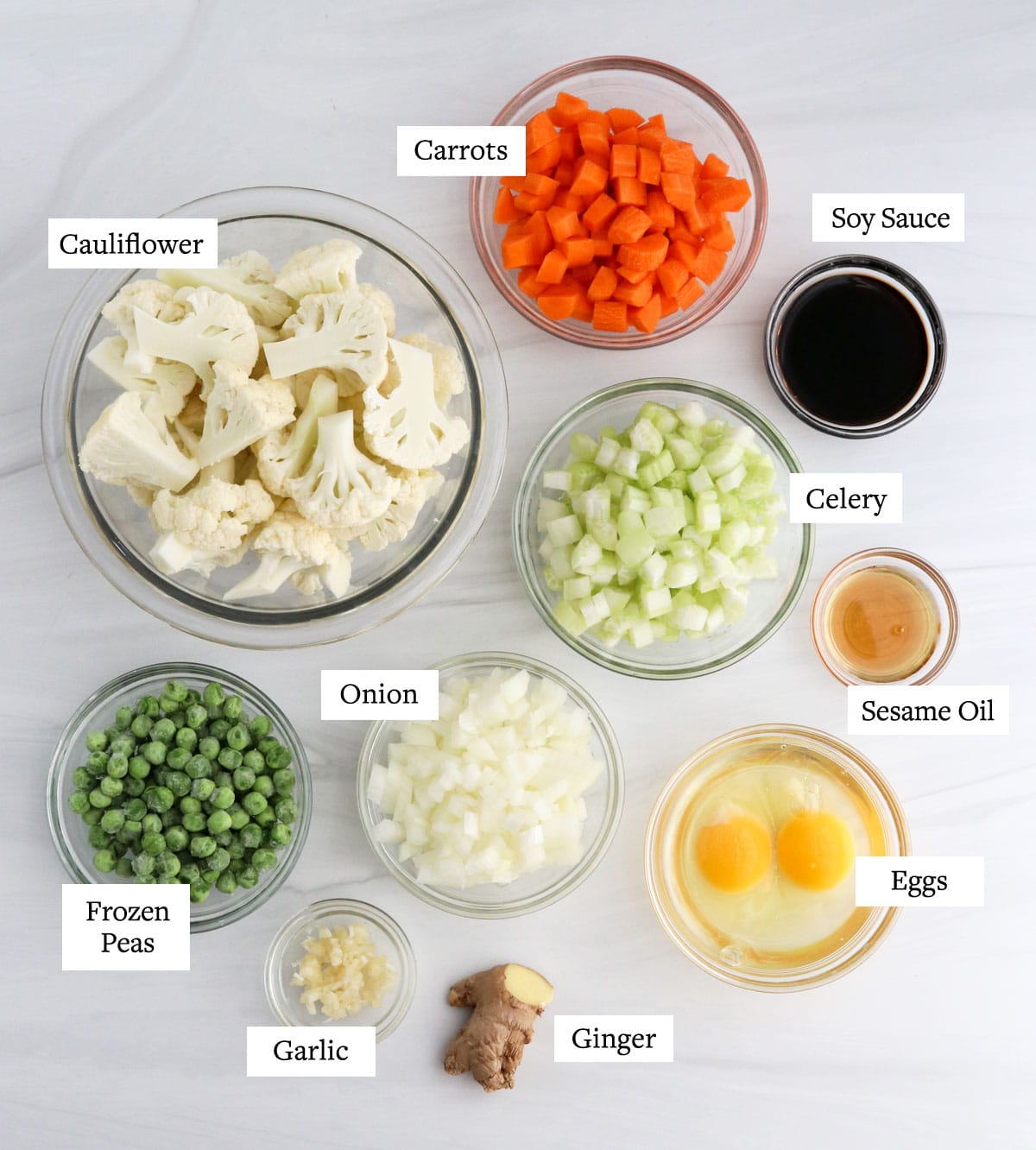 cauliflower fried rice ingredients in glass bowls.