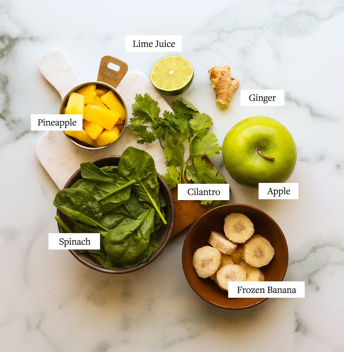 detox smoothie ingredients labeled on a marble surface.
