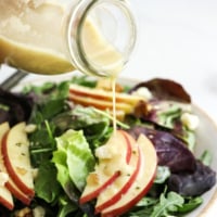 champagne vinaigrette poured over salad from a bottle.