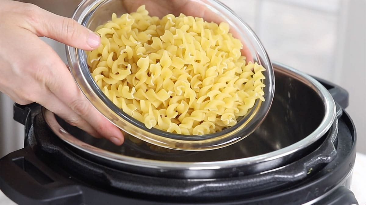 short cut pasta being poured into the Instant Pot