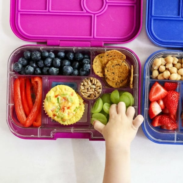 kid lunch box with hand reaching for grapes